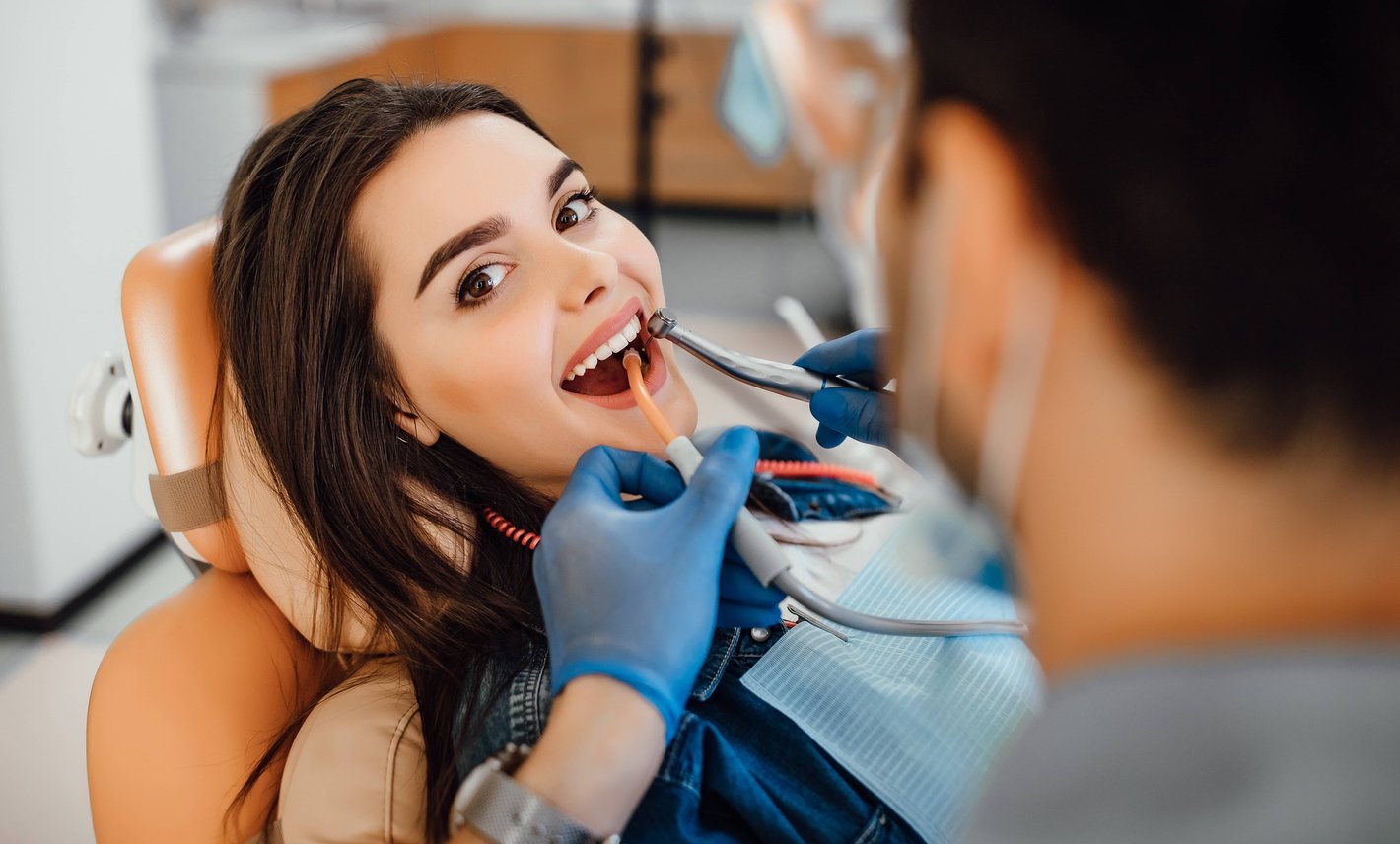 Dentist performing dental procedure on young woman