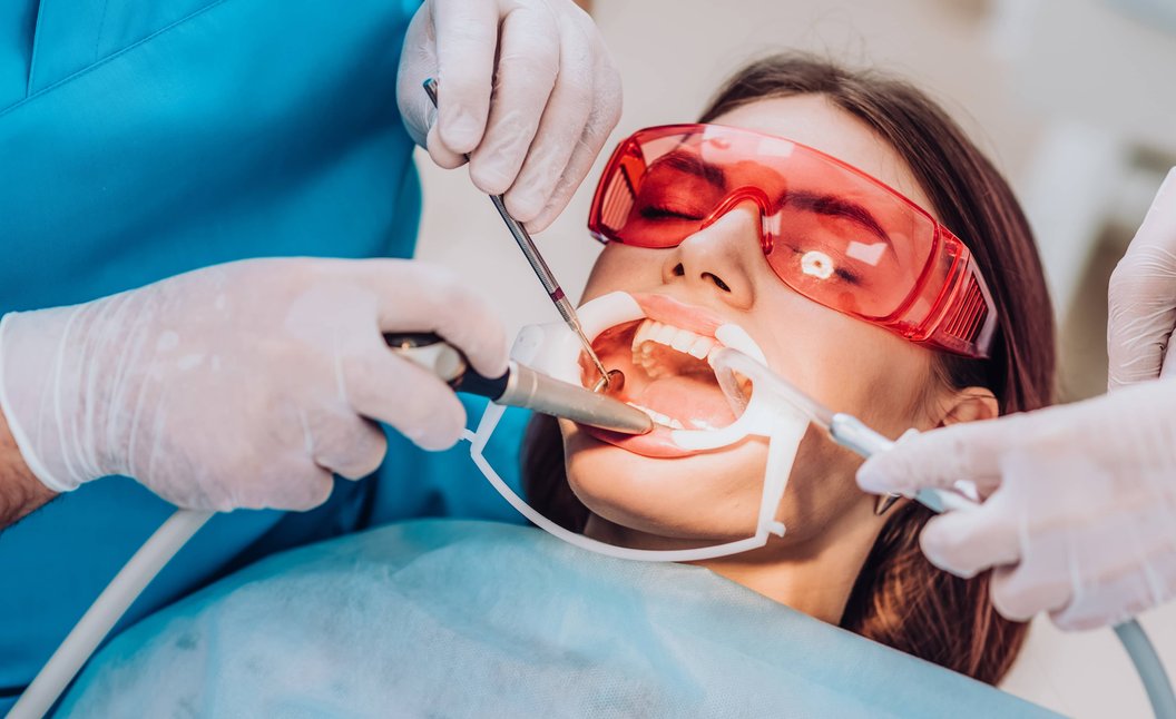 Dentist performing dental procedure on patient with protective eyewear